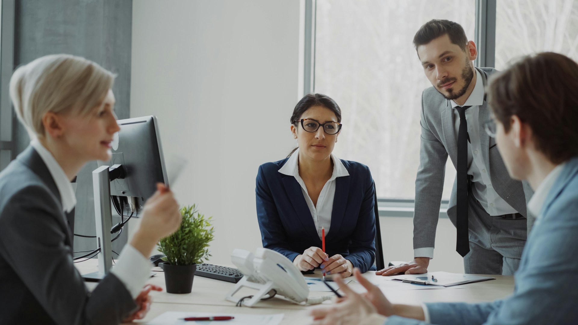 A team meeting around a conference table to review client feedback and reviews